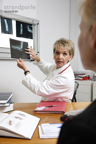 Ärztin in einem Krankenhaus spricht mit einem Patienten