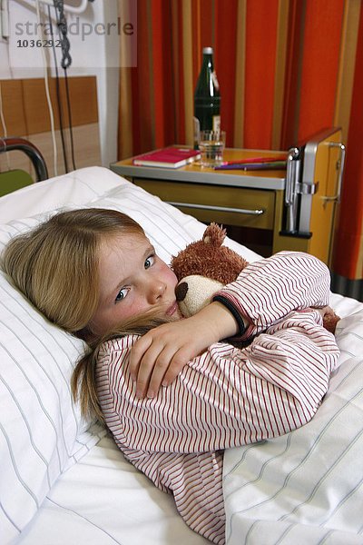 Eine Ärztin in einem Krankenhaus spricht mit einem Patienten  ein junges Mädchen  7 Jahre alt  in einem Krankenhausbett