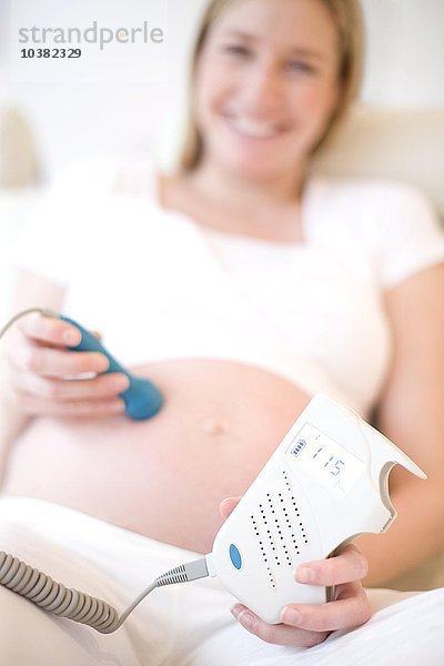 Schwangere Frau mit einem Doppler-Monitor