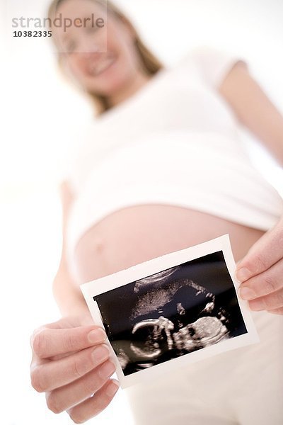 Schwangere Frau hält ihr Baby in der Hand