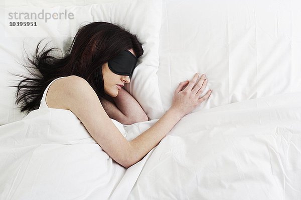 Junge Frau schläft mit Schlafmaske