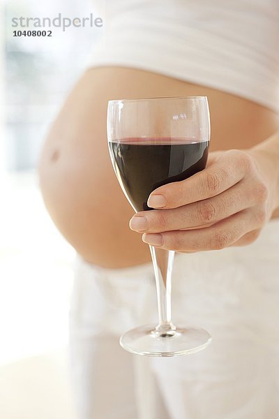 Schwangere Frau mit einem Glas Wein