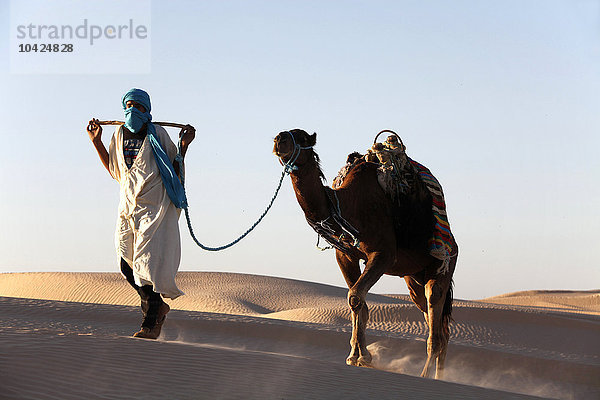 Kameltreiber in der Wüste Sahara.