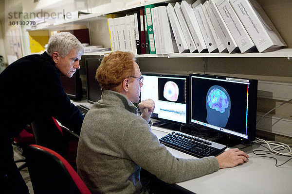 Reportage im Forschungszentrum für Neuroimaging im Krankenhaus Pitie Salpetriere in Paris  Frankreich. Plattform für Magnetoenzephalographie (MEG). Mit der MEG werden Schwankungen im Magnetfeld des Gehirns bei verschiedenen Arten von Hirnaktivitäten festgestellt. Sie dient der Untersuchung normaler und abnormaler Gehirnfunktionen. Die Aufzeichnung des von neuronalen Strömen erzeugten Magnetfelds erfordert hochempfindliche Sensoren  so genannte SQUIDs (Superconducting Quantum Interference Device). Mit den 306 Sensoren  die über 102 Bereiche verteilt sind  können sowohl nahe als auch ferne Magnetfelder gemessen und die tiefen Strukturen des Gehirns sichtbar gemacht werden. Denis Schwartz und Antoine Ducorps betrachten die Ergebnisse eines gesunden Patienten  der visuell stimuliert wurde. Das rechte Bild kombiniert einen MRT-Scan mit dem MEG.