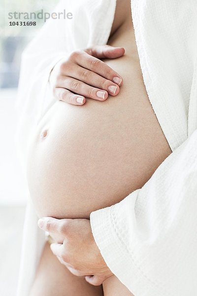 MODELL FREIGEGEBEN. Unterleib einer schwangeren Frau. Sie ist im siebten Monat schwanger.
