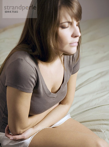 junge Frau mit Unterleibsschmerzen