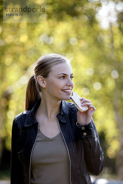 Mädchen isst einen Snack im Park