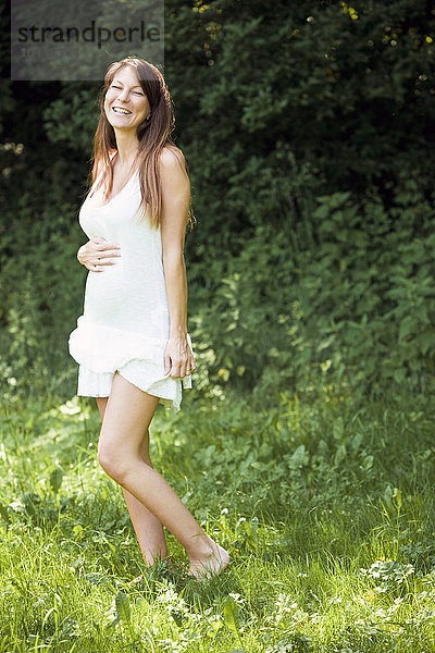 schwangere Frau im weißen Kleid