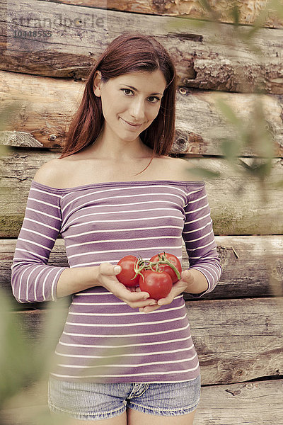 Frau hält Tomate