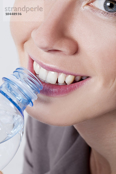 lächelnde Frau beim Wassertrinken