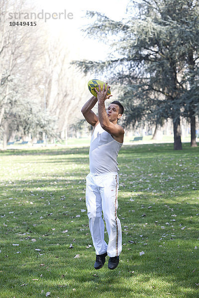 Mann spielt Fußball im Park