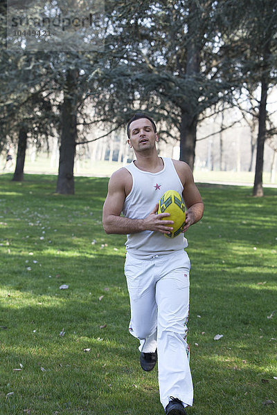 Mann spielt Fußball im Park