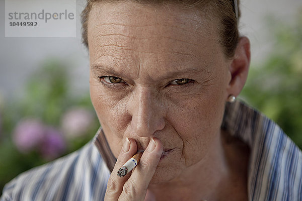 wütende Frau  die eine Zigarette raucht