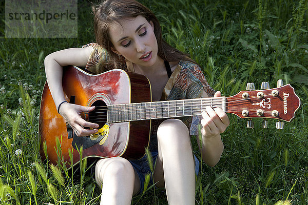 Junge Frau beim Gitarrenspielen