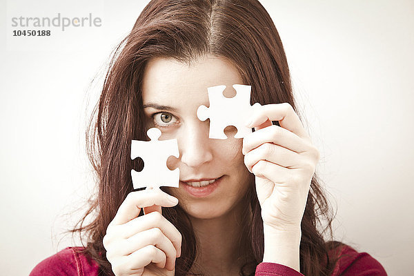 Frau mit zwei Teilen eines Puzzles