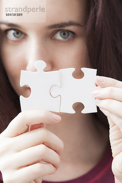 Frau mit zwei Teilen eines Puzzles