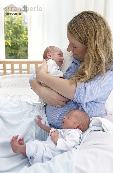 MODELL FREIGEGEBEN. Mutter und zwei Wochen alte zweieiige Zwillinge Mutter und zwei Wochen alte Zwillinge