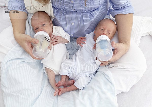 MODELL FREIGEGEBEN. Mutter füttert zwei Wochen alte zweieiige Zwillinge Mutter füttert zwei Wochen alte Zwillinge