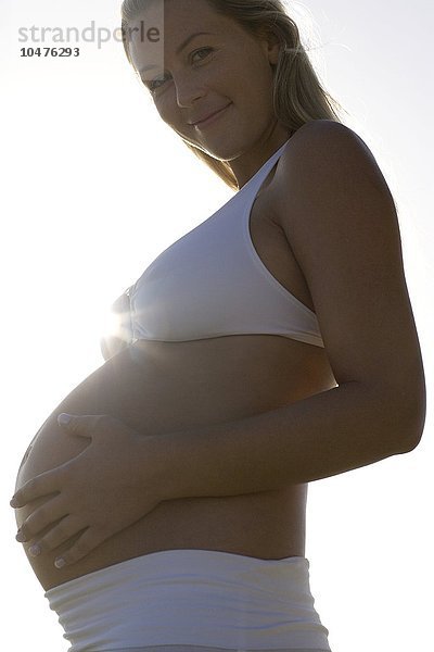 MODELL FREIGEGEBEN. Schwangere Frau fühlt ihren geschwollenen Bauch Schwangere Frau