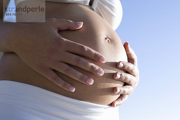 MODELL FREIGEGEBEN. Schwangere Frau hält ihren Bauch Schwangere Frau