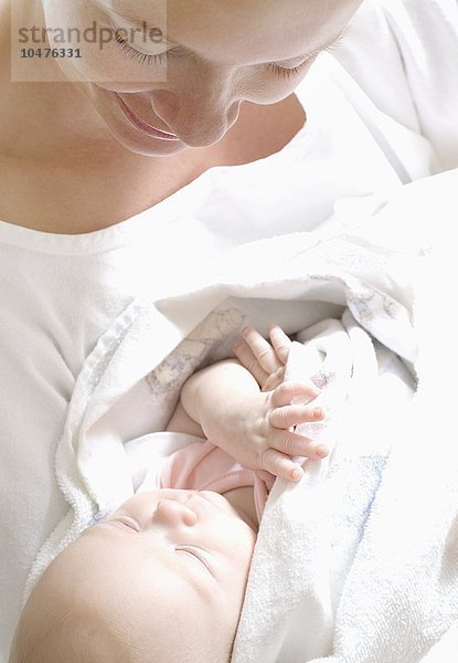 MODELL FREIGEGEBEN. Mutter und neugeborenes Baby. Frau in einer Entbindungsstation hält ihr neugeborenes Baby Mutter und neugeborenes Baby