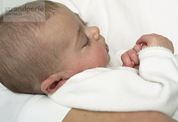 MODELL FREIGEGEBEN. Kleines Mädchen. 12 Wochen altes Mädchen schläft in den Armen ihrer Mutter Baby girl