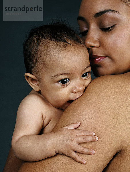 MODELL FREIGEGEBEN. Mutter hält ihr kleines Mädchen. Sie ist sechs Monate alt. Mutter hält ihr Baby