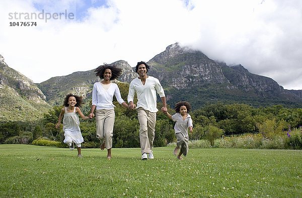 MODELL FREIGEGEBEN. Glückliche Familie. Eltern  die mit ihren beiden Kindern auf dem Land laufen  glückliche Familie