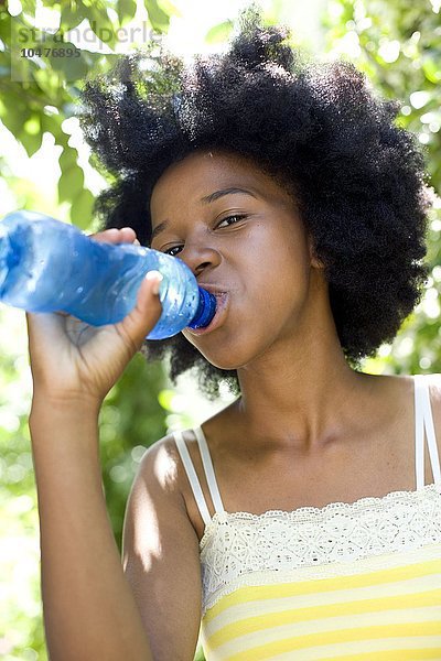 MODELL FREIGEGEBEN. Teenager-Mädchen trinkt Wasser aus einer Flasche Teenager-Mädchen trinkt Wasser