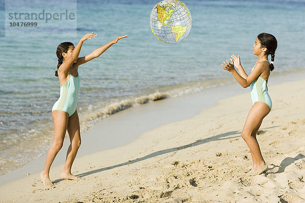 MODELL FREIGEGEBEN. Schwestern spielen Fangen am Strand Schwestern spielen Fangen