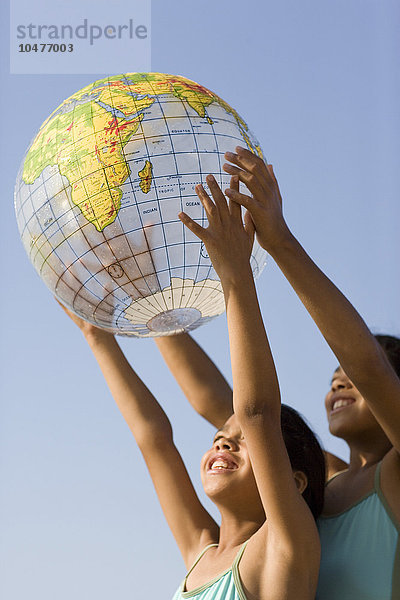 MODELL FREIGEGEBEN. Mädchen halten einen aufgeblasenen Globus Mädchen halten einen aufgeblasenen Globus