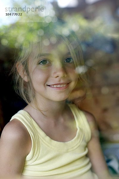 MODELL FREIGEGEBEN. Mädchen spielt in einem Wendy-Haus. Sie ist acht Jahre alt. Mädchen spielt in einem Wendy-Haus