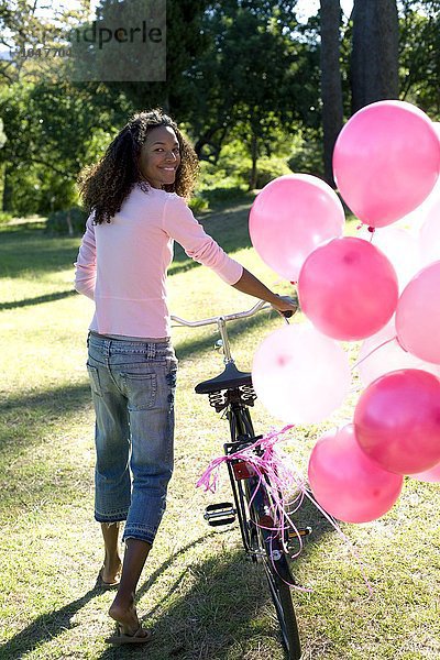 MODELL FREIGEGEBEN. Frau mit einem Fahrrad und Luftballons Frau mit einem Fahrrad und Luftballons