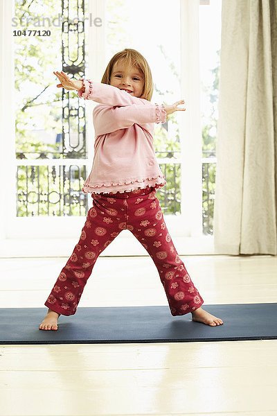 MODELL VERÖFFENTLICHT. Bewegung in der Kindheit. Mädchen tanzt auf einer Yogamatte. Sie ist vier Jahre alt. Childhood exercise