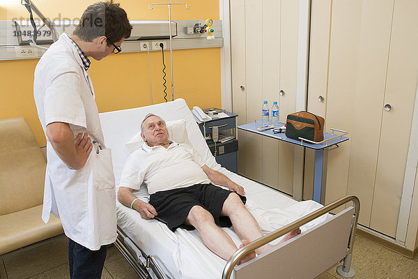 Reportage in der Abteilung für Innere Medizin und Geriatrie im Krankenhaus Saint-Philibert in Lille  Frankreich. Ein Externer unterhält sich mit einem Patienten in seinem Krankenzimmer.
