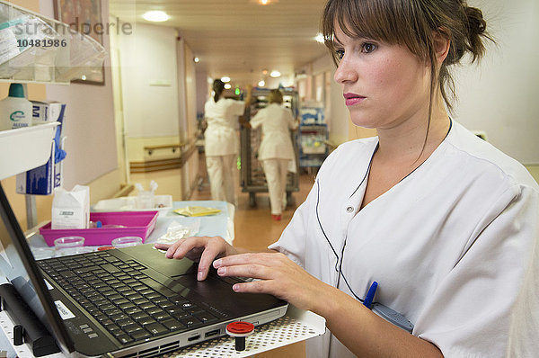 Reportage in der Geriatrie des Saint-Vincent de Paul Krankenhauses in Lille  Frankreich. Eine Krankenschwester ergänzt die Computerdatei eines Patienten in einem der Krankenhauskorridore.