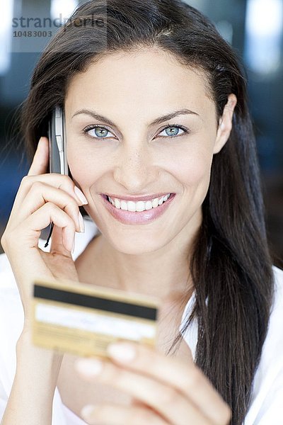 MODELL FREIGEGEBEN. Kauf mit Kreditkarte. Frau  die eine Kreditkarte benutzt  um einen Kauf über das Telefon zu tätigen Kauf mit Kreditkarte