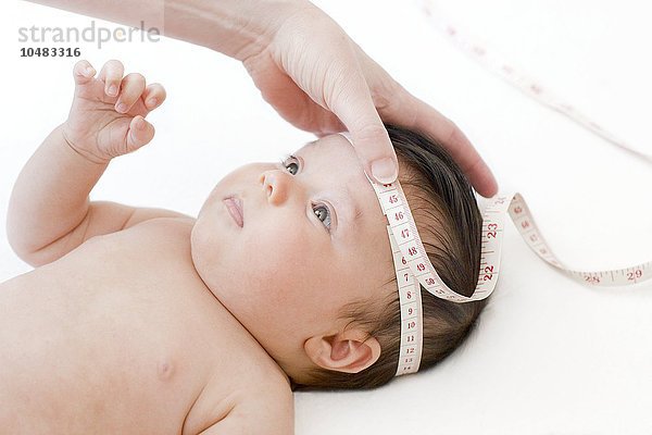 MODELL FREIGEGEBEN. Pädiatrische Untersuchung. Sechzehn Wochen altes Baby  dem der Kopf vermessen wird  pädiatrische Untersuchung