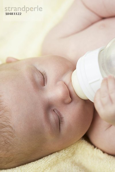 MODELL FREIGEGEBEN. Ein kleiner Junge trinkt aus einer Flasche. Er ist drei Monate alt. Baby boy