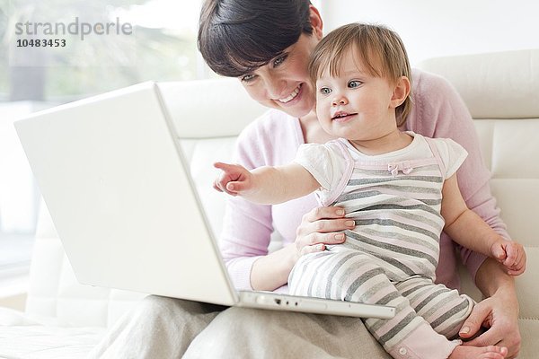 MODELL FREIGEGEBEN. Mutter und Tochter. Mutter und ihre 15 Monate alte Tochter benutzen einen Laptop Mutter und Tochter
