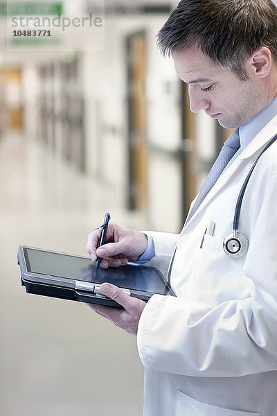 MODELL FREIGEGEBEN. Arzt  der einen Tablet-PC benutzt Arzt  der einen Tablet-PC benutzt