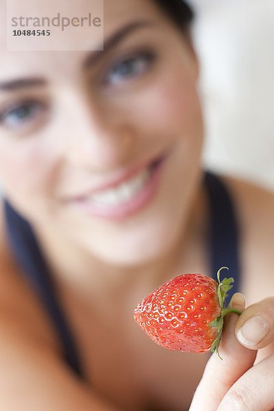 MODELL FREIGEGEBEN. Gesunde Ernährung. Frau isst eine Erdbeere Gesunde Ernährung