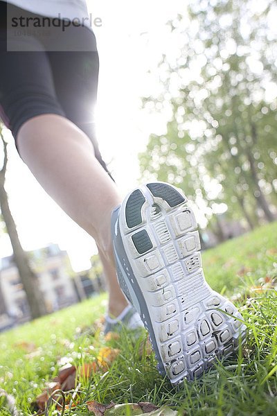 MODELL FREIGEGEBEN. Frau joggt in einem Park Frau joggt