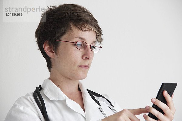 Arzt  der ein Mobiltelefon benutzt Arzt  der ein Mobiltelefon benutzt