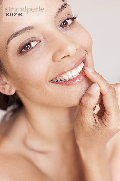 MODELL FREIGEGEBEN. Frau trägt Lippenbalsam auf Frau trägt Lippenbalsam auf