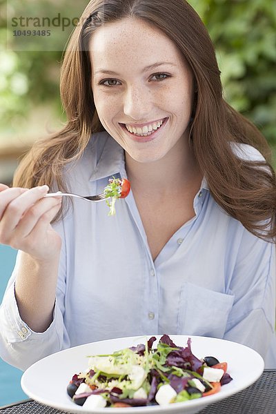 MODELL FREIGEGEBEN. Junge Frau isst einen Salat Junge Frau isst einen Salat