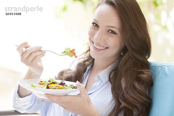 MODELL FREIGEGEBEN. Junge Frau isst einen Salat Junge Frau isst einen Salat