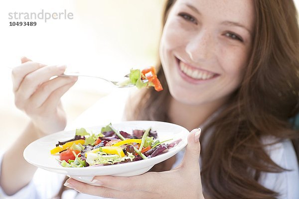 MODELL FREIGEGEBEN. Junge Frau isst einen Salat Junge Frau isst einen Salat