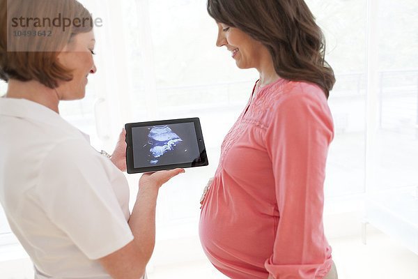 MODELL FREIGEGEBEN. Schwangere Frau mit Baby-Scan Schwangere Frau mit Baby-Scan