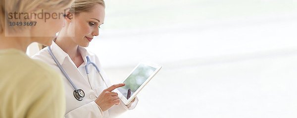MODELL FREIGEGEBEN. Arzt  der einen Tablet-Computer benutzt Arzt  der einen Tablet-Computer benutzt